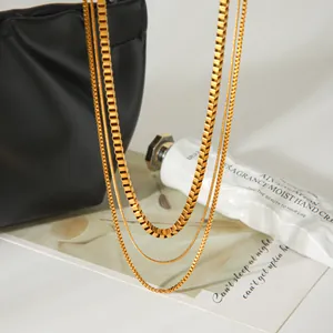 Détail d'un collier multicouche minimaliste en acier inoxydable doré avec différentes chaînes