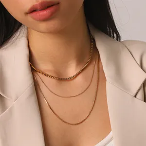 Gros plan détaillé du collier à trois couches en acier inoxydable doré sur un mannequin