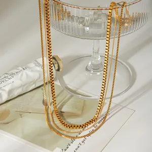 Détail montrant les textures du collier à trois couches en maille gourmette et serpent