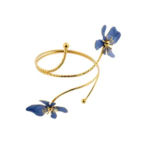 Brazalete de brazo en espiral dorado vintage con flores de esmalte azul fondo blanco
