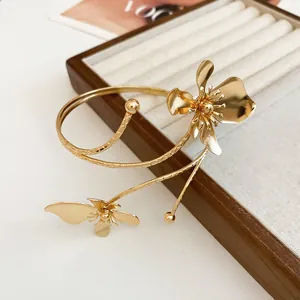 Detalle de un sofisticado brazalete de brazo dorado vintage con un diseño floral único.