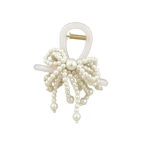 Elegant French style hair claw clip with faux pearl bow design on pure white background