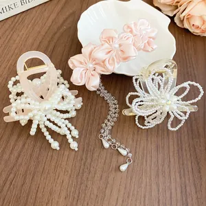 Detailed view of three sweet Korean style pearl and floral hair clips on a wooden table