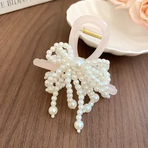 Close-up of a sweet pearl bow hair claw clip with cascading pearls and tassels