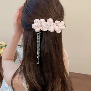 Back view of a sweet pink satin flower hair clip with pearl tassel detail