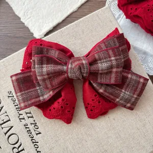 Detail of multi-layer red lace and plaid bow hairpin with vintage eyelet embroidery