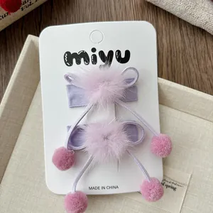 Vue détaillée des barrettes nœuds en peluche avec tissu lavande et pompons en fausse fourrure