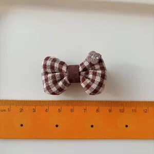 Plaid fabric bow hair clip for girls with small flower detail and 5.5cm width measurement