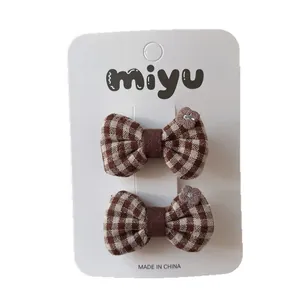 Brown checkered bow hair clips with purple flower embroidery for girls on white card