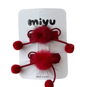 Paire de barrettes à cheveux rouges avec pompons en peluche et détails perlés