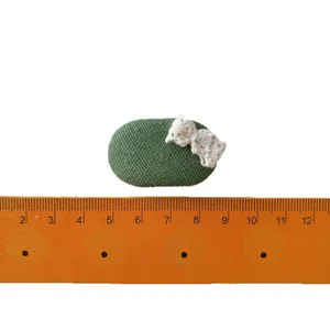 Green canvas oval hair clip with white crochet bow and ruler for scale 3.5cm