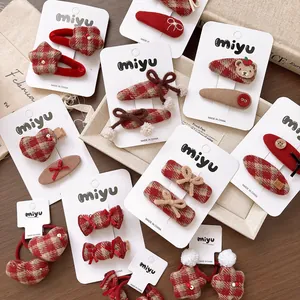 Detail of red and brown tartan hair clips including stars and bows on display card
