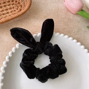 Detail of black velvet scrunchie with rabbit ear design on a decorative plate