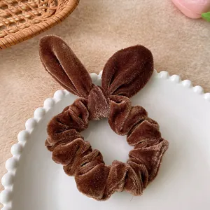 Detail view of dark brown velvet scrunchie with rabbit ear knot on white tray