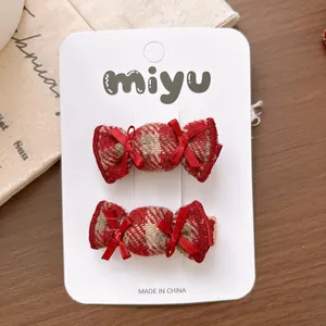 Close-up of sweet red and white checkered candy-shaped hair clips with ribbon bows