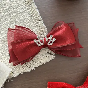 Dettaglio fiocco in velluto bordeaux con corona d'argento e strass scintillanti