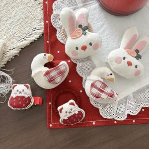 Detailopname van pluche haaraccessoires met geborduurde konijntjes, beertjes en eendjes