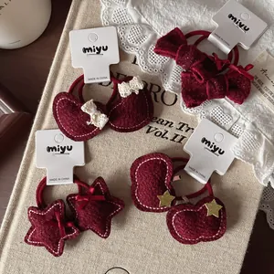 Detail van donkerrode kinderhaarelastiekjes set met hartjes en strikjes van vilt