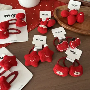 Détail d'accessoires de cheveux tricotés rouges avec nœud, étoile et pomme enfant