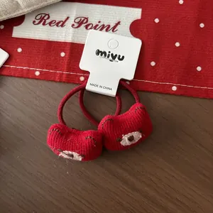 Paire d'élastiques à cheveux ours en tricot rouge pour filles sur carte blanche