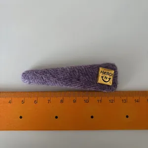 Sweet purple fabric BB hair clip with a gold Hello label and smiley face detail
