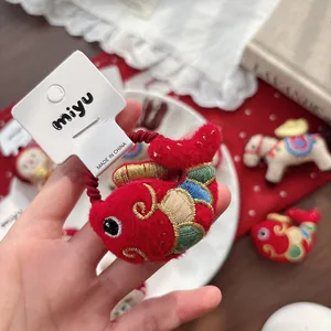 Traditional red embroidered koi fish hair tie with golden scale details for Lunar New Year