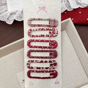 Détail de 6 barrettes rouges pour cheveux avec motifs léopard et carreaux vintage