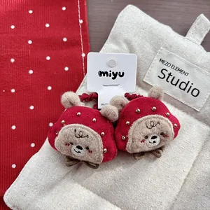 Close-up of cute red plush bear hair ties with embroidery and beads for children