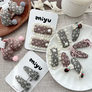 Detailed flat lay of floral fabric bunny ear hair ties and lace pearl clips for girls