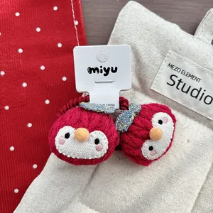 Detail of cute knitted penguin hair ties with high-elastic red bands for children