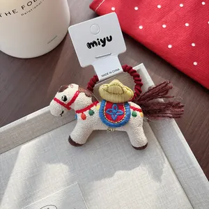 Close-up of cute festive horse hair tie with detailed floral embroidery and red elastic band