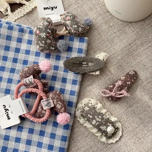 Floral fabric children hair clip set with lace borders and handmade plush pom detail