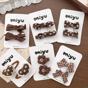 Détail d'un lot de barrettes à cheveux à nœuds marron et pois de style coréen