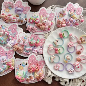 Lot d'élastiques à cheveux colorés avec charms en résine sur carte de présentation
