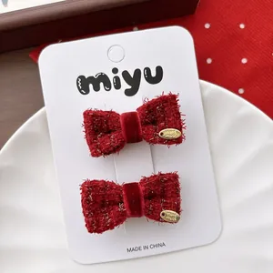 Close-up of red tweed bow hair clips with Hand Made metal plate for New Year