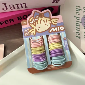Dettaglio di elastici colorati per capelli da bambina su cartoncino rosa in vassoio