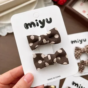 Paire de barrettes à nœuds marrons à pois sur carte pour coiffure de fille