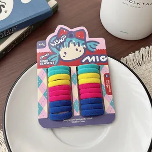 Detail of colorful elastic hair ties for kids displayed on a white plate with home decor