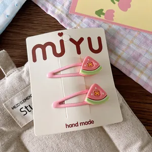 Detail of pink watermelon fruit hair clips set on a handmade display card