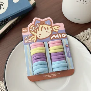 Close-up of candy-colored elastic hair ties for girls on a decorative white plate