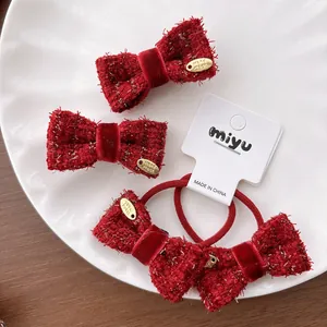 Detailed macro of red tweed bow hair clips and hair ties with golden handmade labels