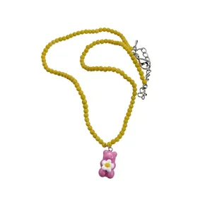 Sweet yellow beaded necklace with a cute pink resin gummy bear pendant and flower detail