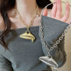 Close-up of gold and silver metallic lip pendant necklaces with textured ridged design