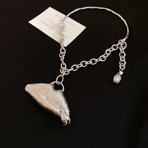 Detailed view of heavy-duty silver lip pendant necklace featuring striped texture and pearl