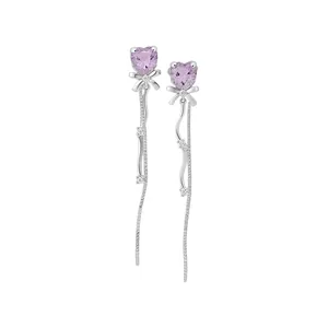 Boucles d'oreilles nœud en argent avec pierres cœur violettes et longs glands brillants.