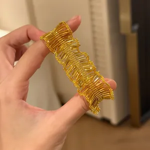 Close-up shot of a vintage pleated gold lace bracelet showing intricate texture