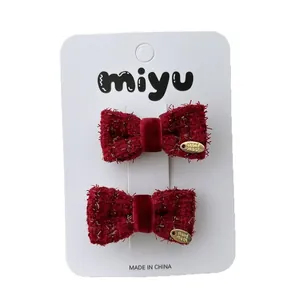 Pair of red tweed bow hair clips for girls with handmade gold charms on white card