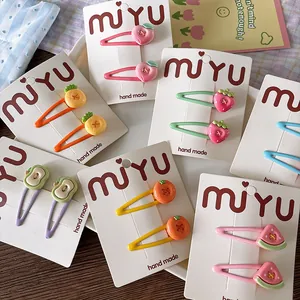 Close-up of cute fruit hair clips including strawberry and peach on a display card
