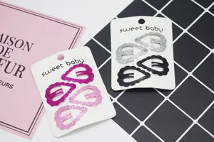 Détail de pinces à cheveux pailletées en rose et noir présentées sur cartes