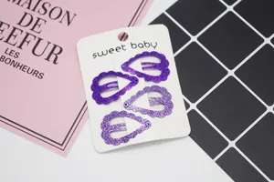Lot de quatre barrettes en forme de cœur à paillettes violettes sur carte cadeau